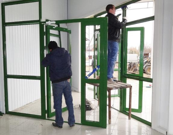 Мастера демонтируют двери из алюминиевого профиля